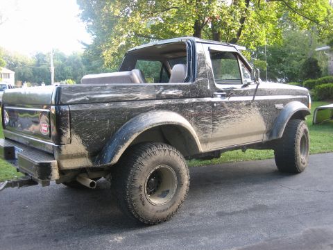 1995 Ford Bronco - This muddy Ford Bronco is shown from a rear three-quarter angle.