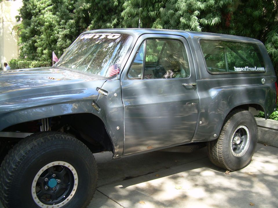 Modified SUV with off-road tires and fender flares. Sticker on rear window reads 'bmsoffroad.com'