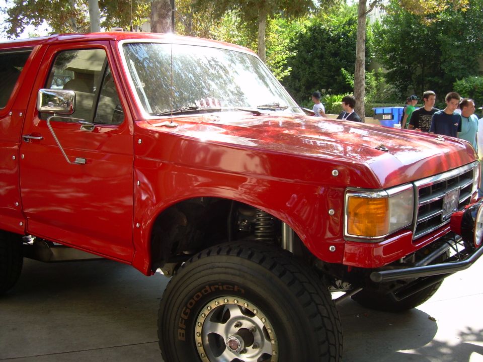 Red 1986 Ford Bronco 3q-front view with aftermarket bumper and wheels