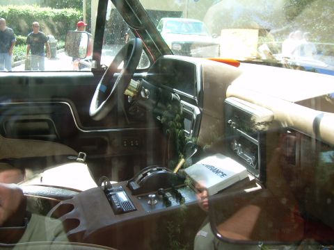 1986 Ford Bronco - The interior of a truck shows the dashboard, steering wheel, and center console with various controls and a fish finder device.