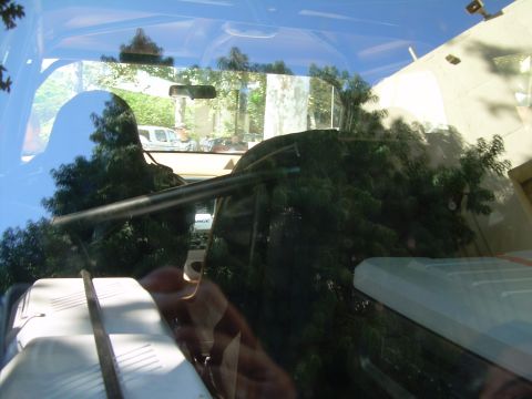 1986 Ford Bronco - Reflections on the windshield obscure the interior details and the exterior scene.