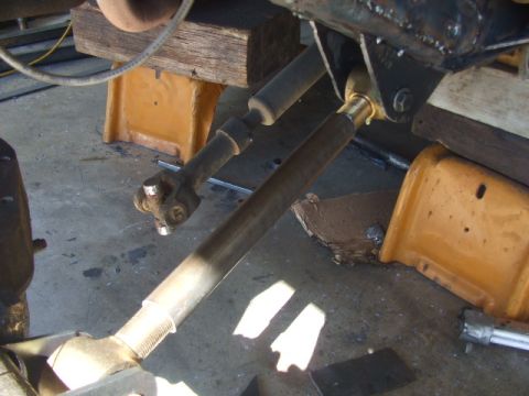 1994 Jeep Cherokee - The photo shows a close-up view of a vehicle's steering linkage and a U-joint, supported by jack stands.