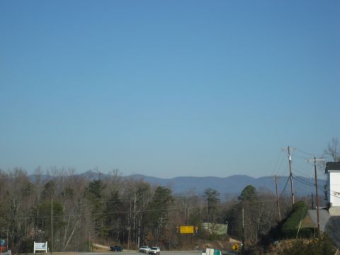 2001 Ford Crown Victoria - Vehicles travel along a highway with a mountainous landscape under a clear blue sky.