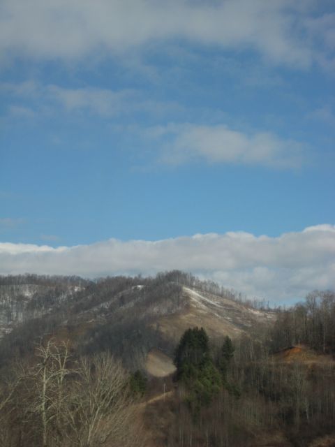 2001 Ford Crown Victoria - A scenic view of rolling hills and a dirt path under a partly cloudy sky.