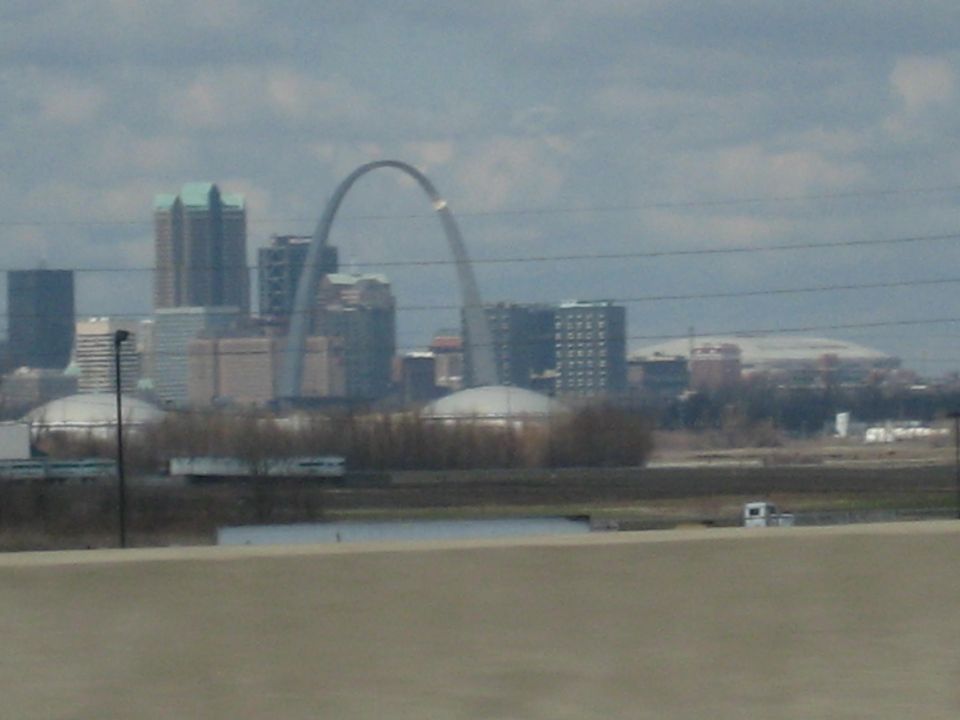 Gateway Arch and St. Louis skyline with buildings and a cloudy sky