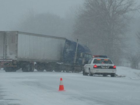 2001 Ford Crown Victoria - A 2001 Ford Crown Victoria police car is seen in snowy conditions next to a semi-truck.