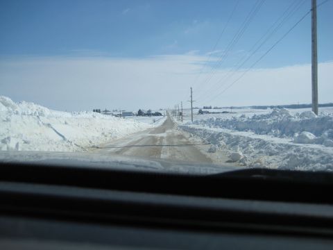 2001 Ford Crown Victoria - Driving down a rural road with high snowbanks on either side under a clear blue sky.