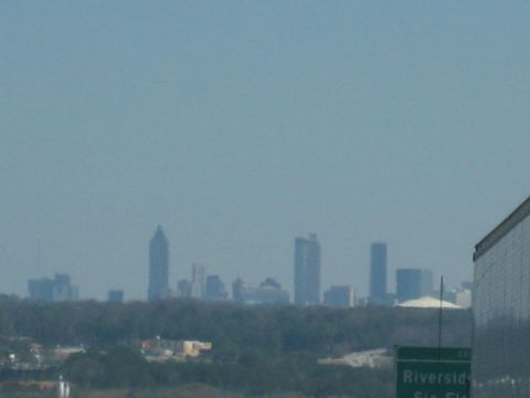 2001 Ford Crown Victoria - A distant city skyline is visible through a hazy sky, with trees and buildings in the foreground.