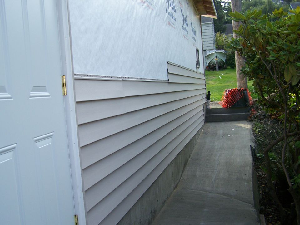 boat on trailer in yard next to house siding