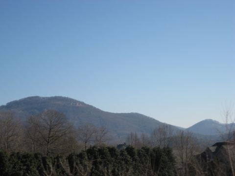 2001 Ford Crown Victoria - Mountain landscape with trees and houses under a clear blue sky. Watermark reads SUPERMOTORS.