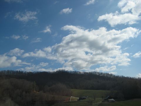 2001 Ford Crown Victoria - A scenic view of a rural landscape under a partly cloudy sky, with a hint of a building in the distance.