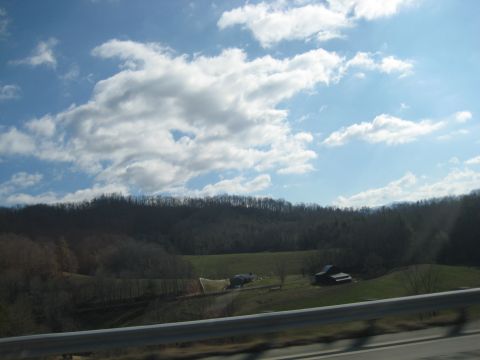 2001 Ford Crown Victoria - View of a rural landscape with barns and hills under a partly cloudy sky.