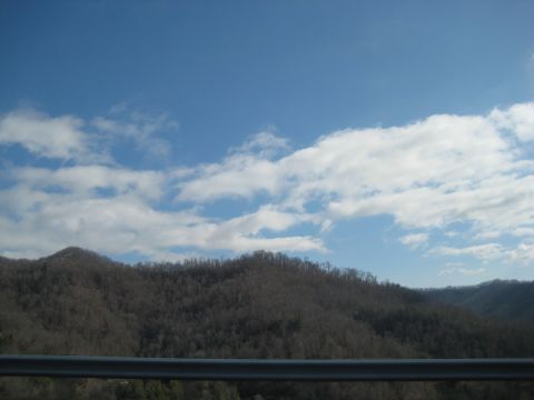 2001 Ford Crown Victoria - A view of a mountain range under a partly cloudy sky, with a guardrail in the foreground.