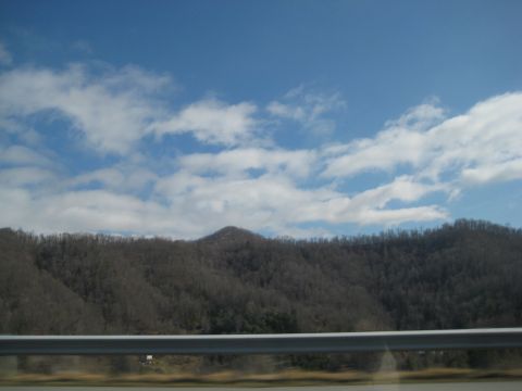 2001 Ford Crown Victoria - View of mountains and sky from a car window, with a metal guardrail in the foreground.