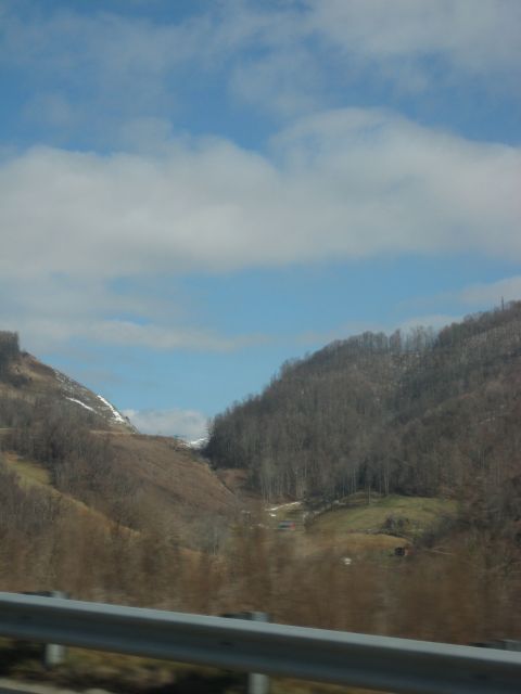 2001 Ford Crown Victoria - A view of a valley between two tree-covered mountains, with a guardrail visible in the foreground.
