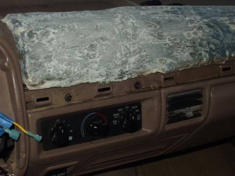 1993 Ford Bronco - The dashboard of a 1993 Ford Bronco shows damage to the top panel and visible HVAC controls.
