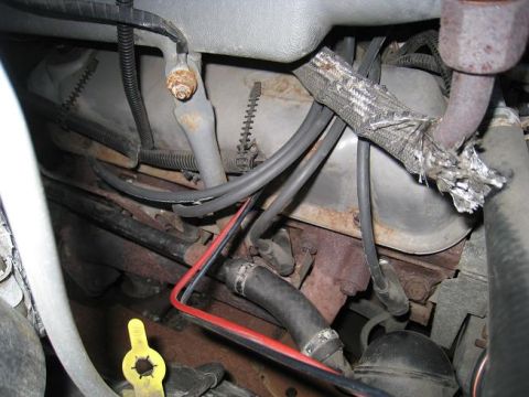 1994 Ford Bronco - A close-up view of engine components, including hoses and wiring, with some signs of wear and tear.