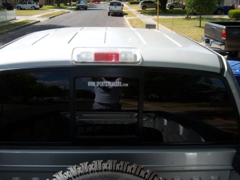 1979 Ford Bronco - This photo shows the rear of a pickup truck parked on a residential street with other vehicles in the background.