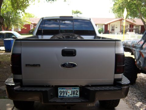 1979 Ford Bronco - This Ford F-150 pickup truck is seen from the rear, parked next to another vehicle.