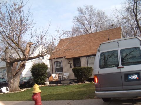 1971 Ford Ranchero - A two-tone van is parked in front of a house, with another car visible in the background.