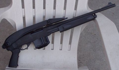 1990 Ford Bronco - A black shotgun with a pistol grip and magazine is placed on a white plastic chair.