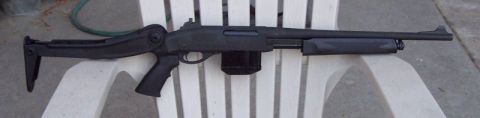 1990 Ford Bronco - A tactical shotgun with an extended magazine rests on a white plastic chair.