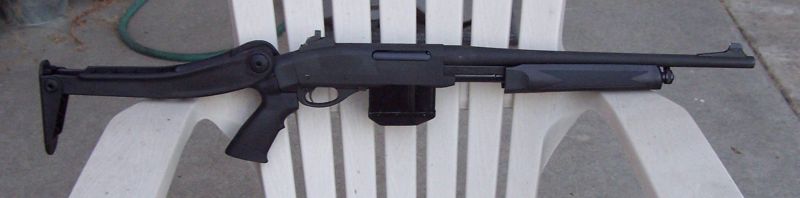 black shotgun with adjustable stock and extended magazine sitting on a white plastic chair