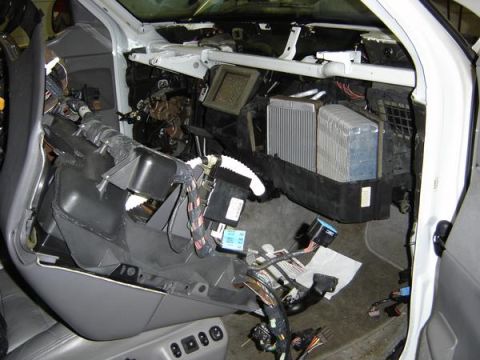 2007 Ford Mustang - Interior with the dash removed, exposing the HVAC plenum, heater/evaporator core, blower and tangled wiring harness during repair.