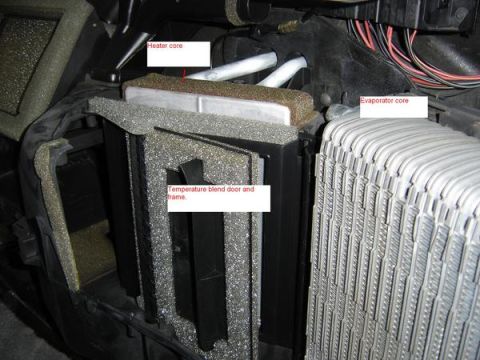 2007 Ford Mustang - Close-up of an HVAC assembly with the case opened, showing the labeled heater core (top), temperature blend door and frame (center), and th…