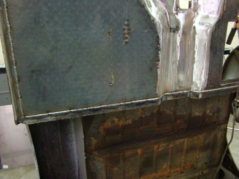 1948 Jeep Wrangler - Detail of a rusty metal panel showing recent welding work, likely part of a vehicle body repair.