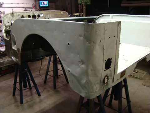 1948 Jeep Wrangler - Body panels of a 1948 Jeep Wrangler are visible in a workshop, undergoing repairs.