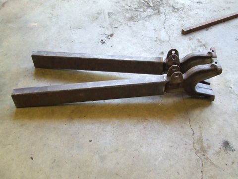 1967 Ford Bronco - Two metal brackets are shown resting on a concrete floor.