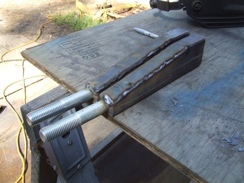 1967 Ford Bronco - Custom metal brackets with threaded bolts are welded together and resting on a piece of plywood.