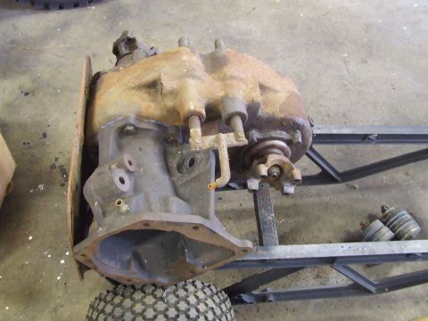 1967 Ford Bronco - A heavily rusted transfer case, likely from an older vehicle, is shown disassembled and mounted on a stand.
