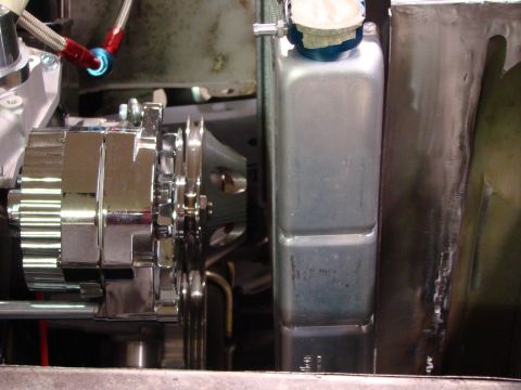 1948 Jeep Wrangler - Close-up view of a chrome alternator and a silver radiator in an engine bay.