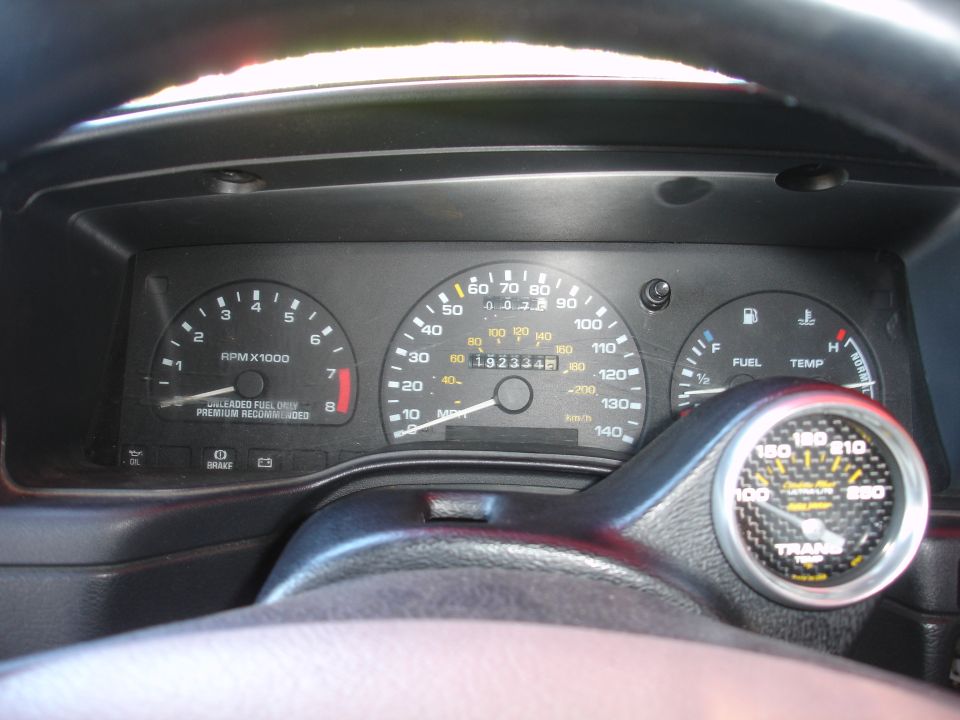 car dashboard with speedometer, tachometer, fuel, and temp gauges. Also has an aftermarket boost gauge