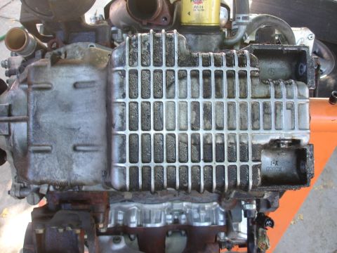 1993 Ford Taurus - Close-up of an engine oil pan, showing its ribbed heat sink and a stamped part number.