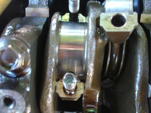 1993 Ford Taurus - Close-up view of an engine's crankshaft bearing and connecting rod bolts, indicating internal engine components.