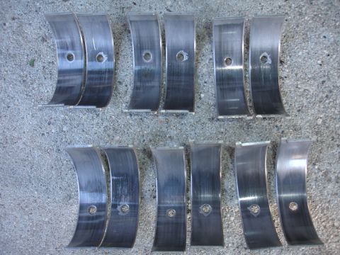 1993 Ford Taurus - Engine bearings laid out on a concrete surface, showing signs of wear.