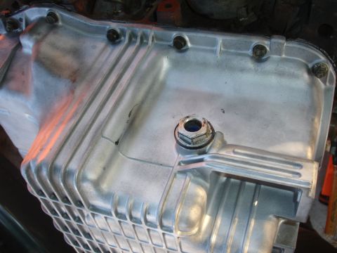 1993 Ford Taurus - This is a close-up view of a vehicle's oil pan, showing its ribbed design and drain plug.