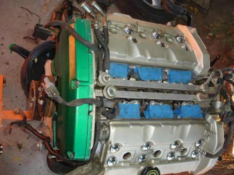 1993 Ford Taurus - Engine assembly with green and silver valve covers and blue tape on the fuel injectors.