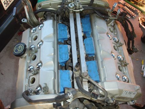 1993 Ford Taurus - Close-up of an engine's valve covers and fuel rail assembly, with blue tape covering the spark plug openings.