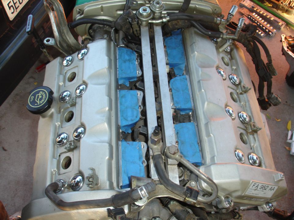 engine with silver valve covers and blue tape on spark plug wells
