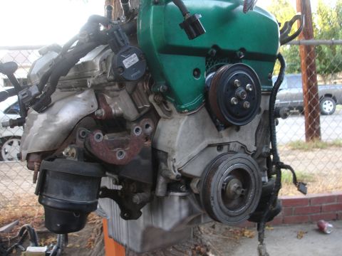 1993 Ford Taurus - This engine assembly features a green valve cover and multiple pulleys, with visible sensors and wiring harnesses.