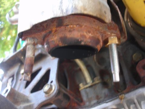 1993 Ford Taurus - Close-up view of a rusty exhaust pipe connection, showing bolts and a metal bracket.