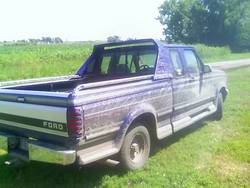 1995 Ford F-150 - 1995 Ford F-150 pickup truck with a custom bed cover and running boards.