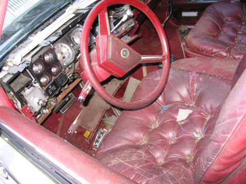 2001 Ford Crown Victoria - Photograph of a sedan's red interior and steering wheel, not a technical document.