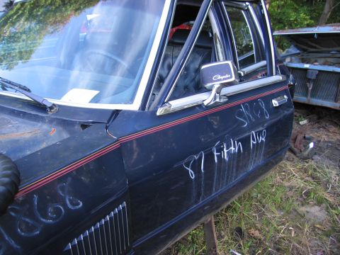 2001 Ford Crown Victoria - Photograph of a Chrysler Fifth Avenue in a salvage yard, not a technical document.