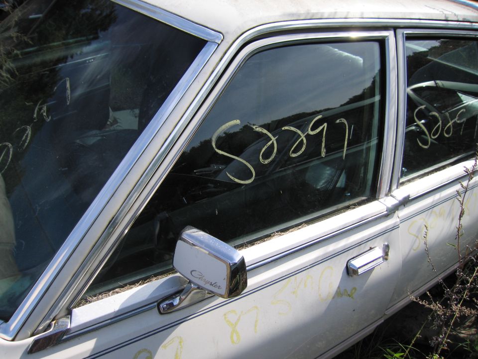Photo of a white car door and window with chalk inventory markings