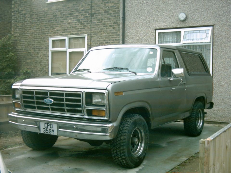Gray 1982 Ford Bronco parked in front of a building.